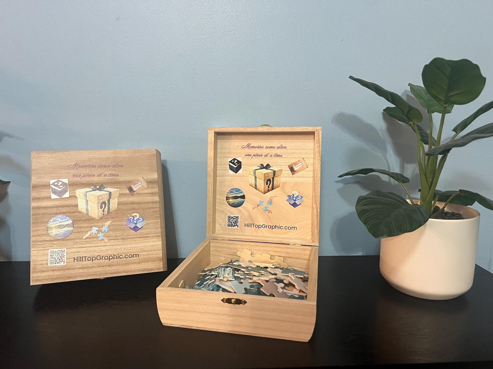 Wooden puzzle box with puzzles inside, on a dark surface with a plant in the background.