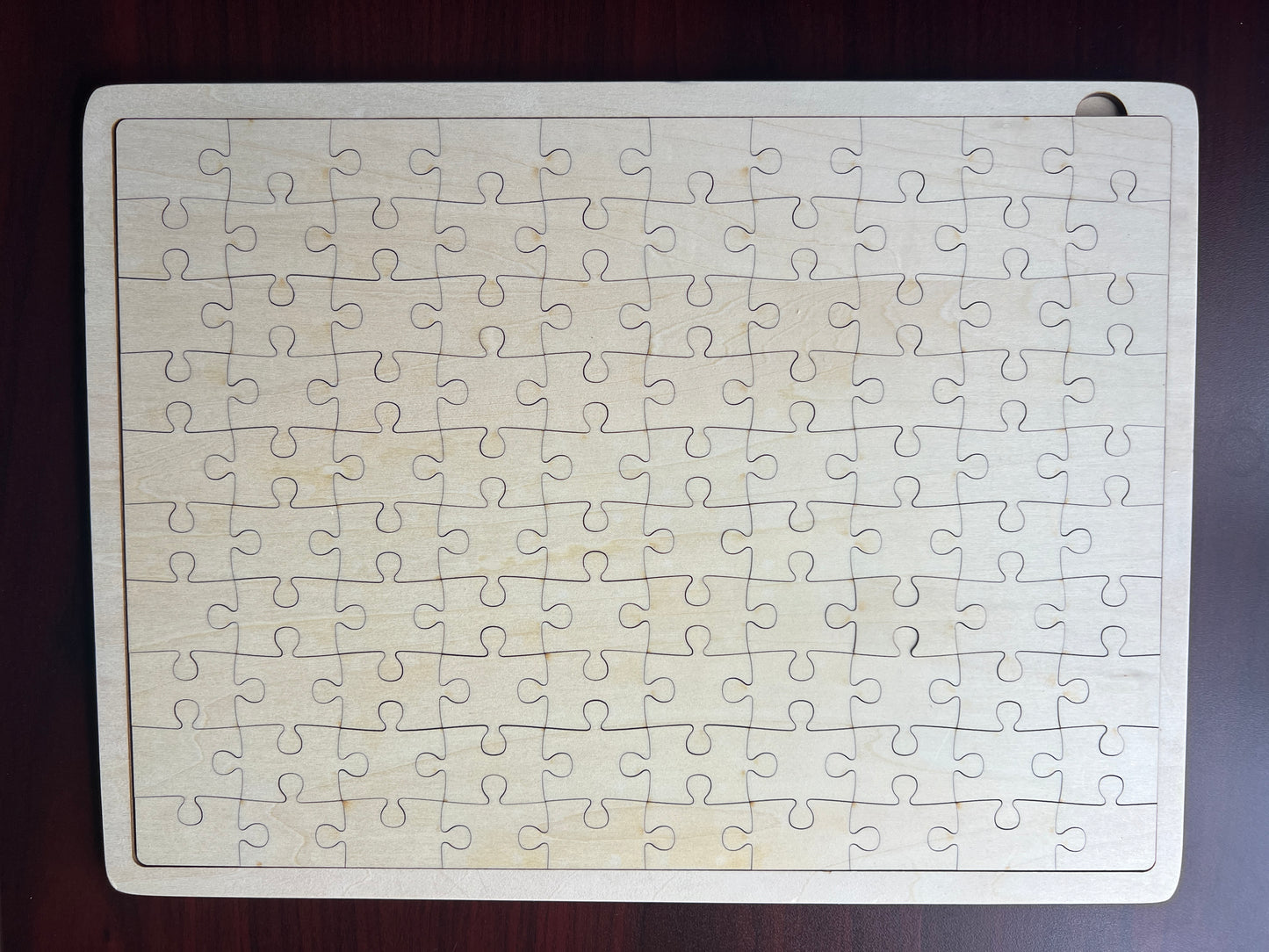 Jigsaw puzzle with all pieces on a wooden surface