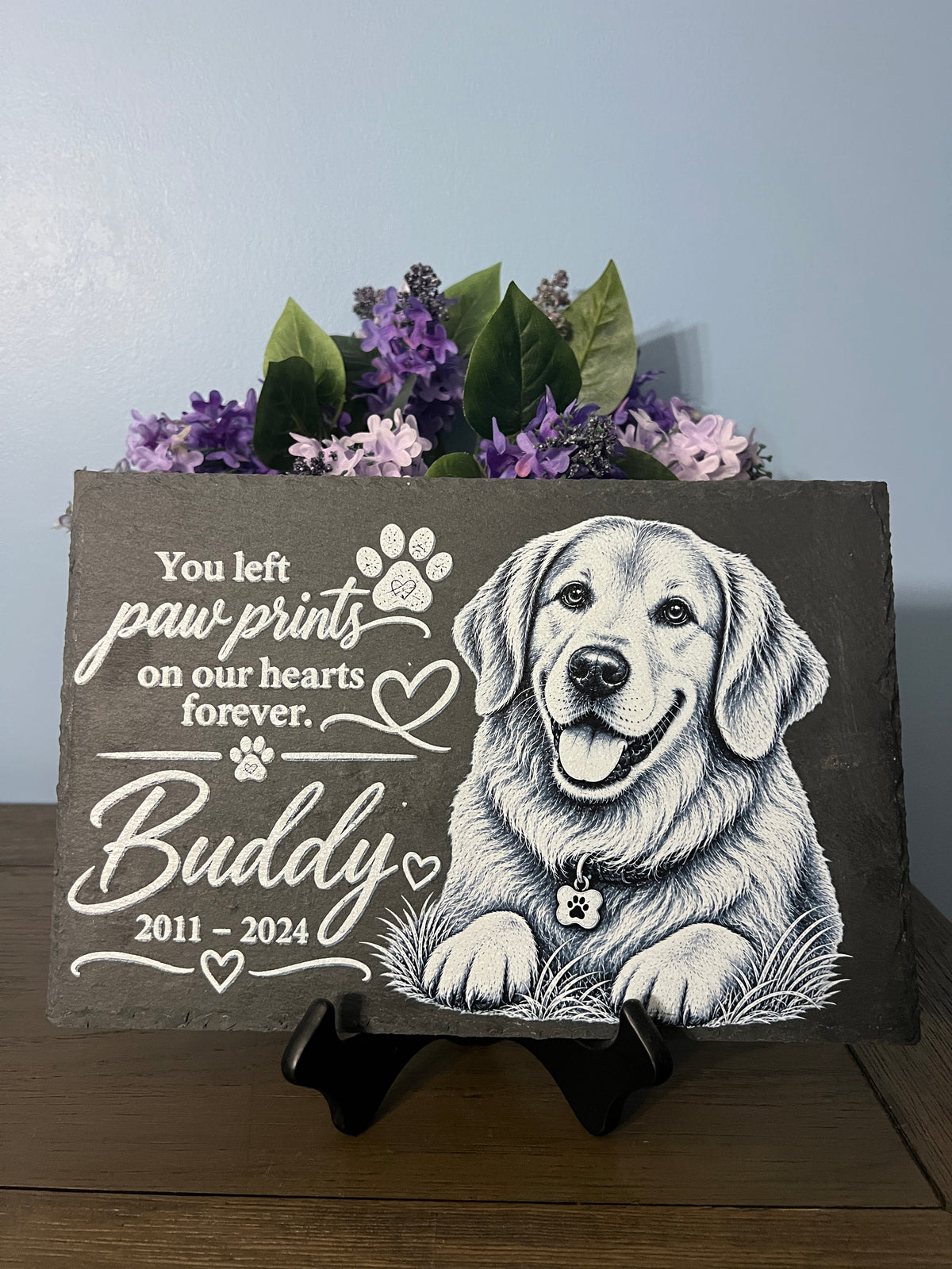 slate with picture of a dog sketch that's says you left paw prints on our hearts forever.  