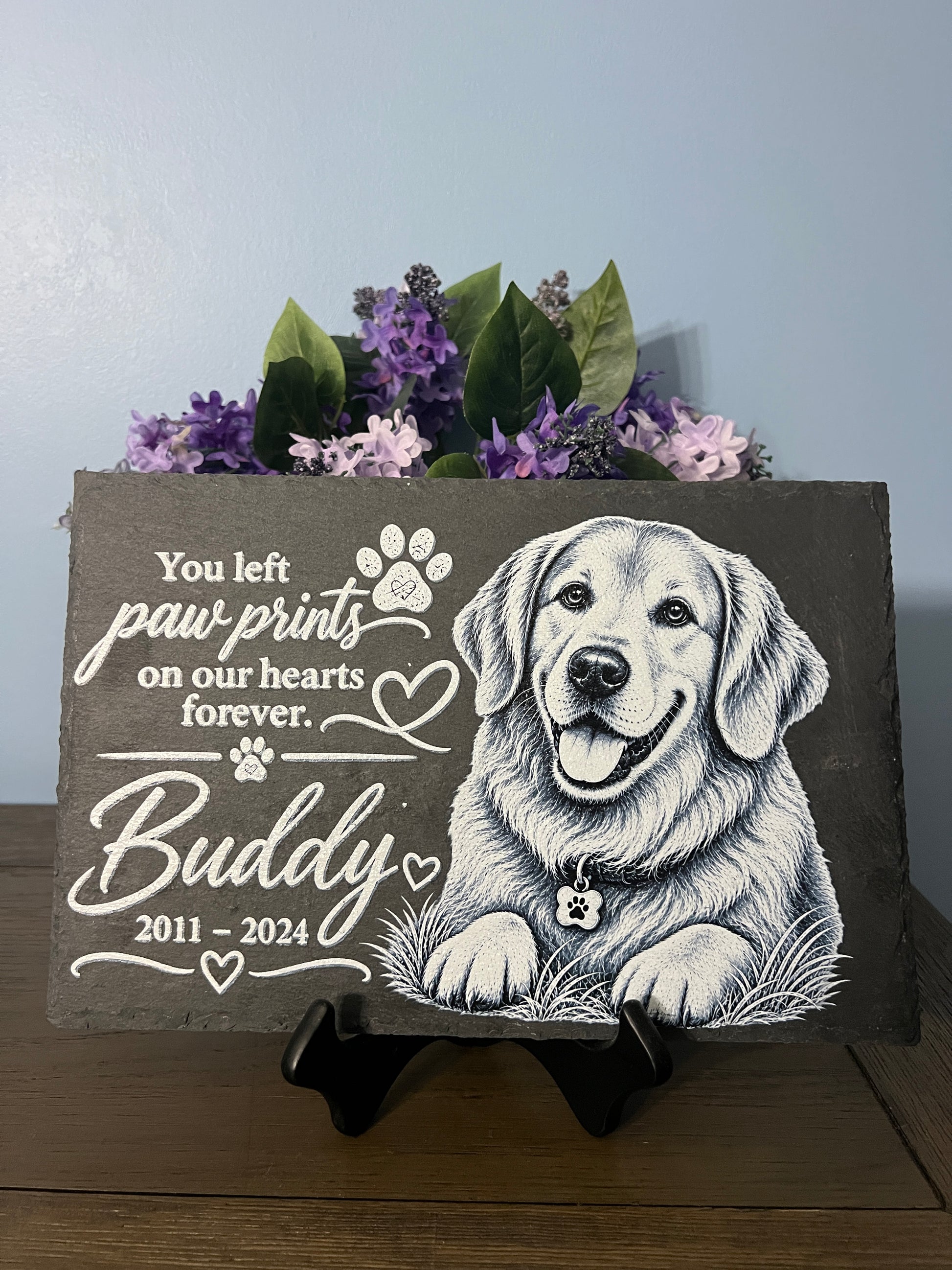 slate with picture of a dog sketch that's says you left paw prints on our hearts forever.  