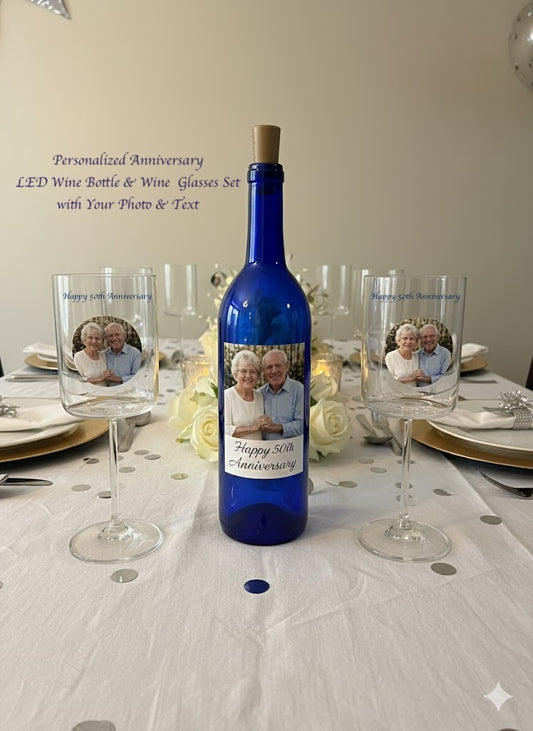 Blue wine bottle with personalized label and two glasses on a table setting.