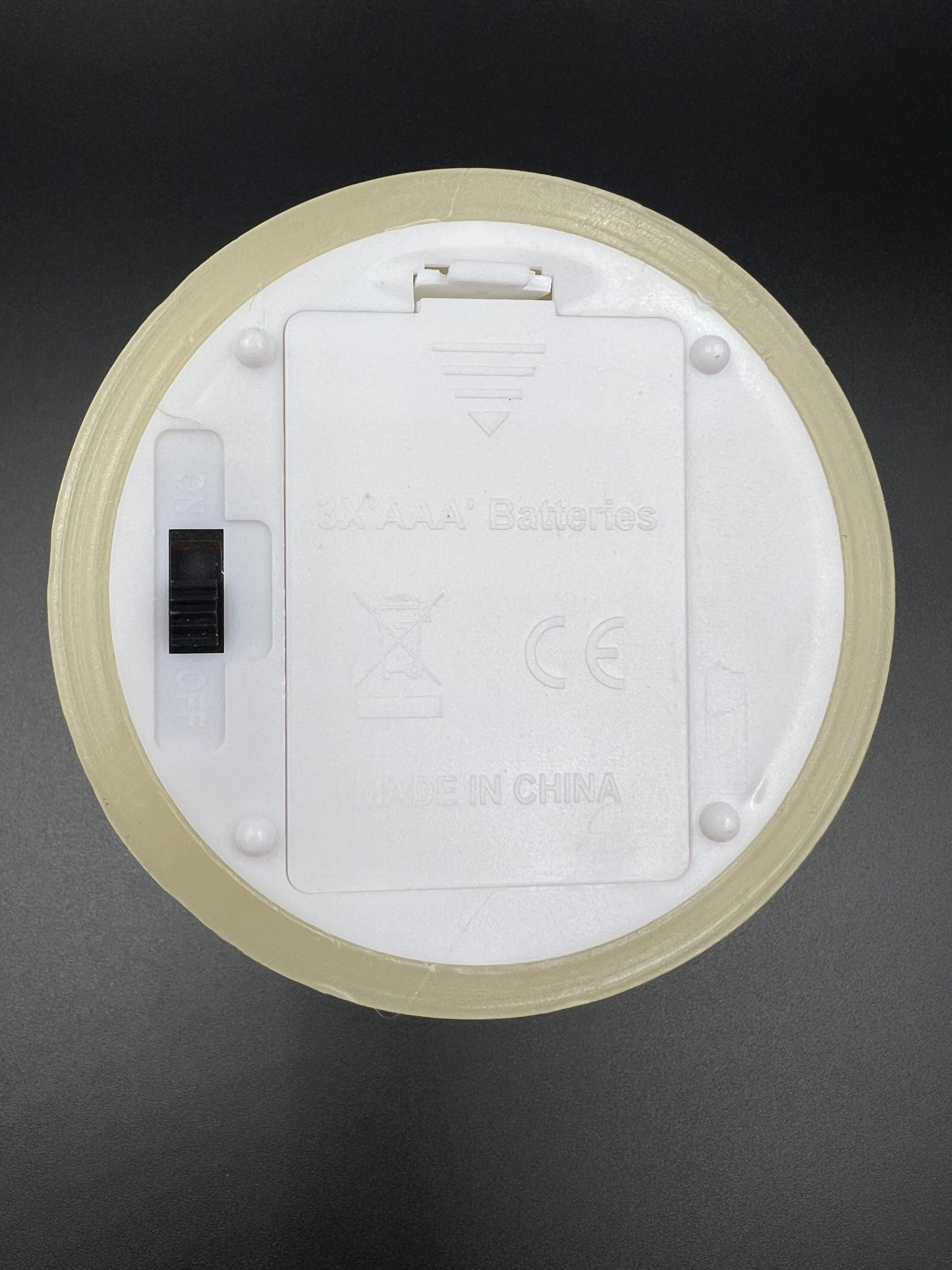 Bottom side of the flameless candle showing on and off switch and battery compartment