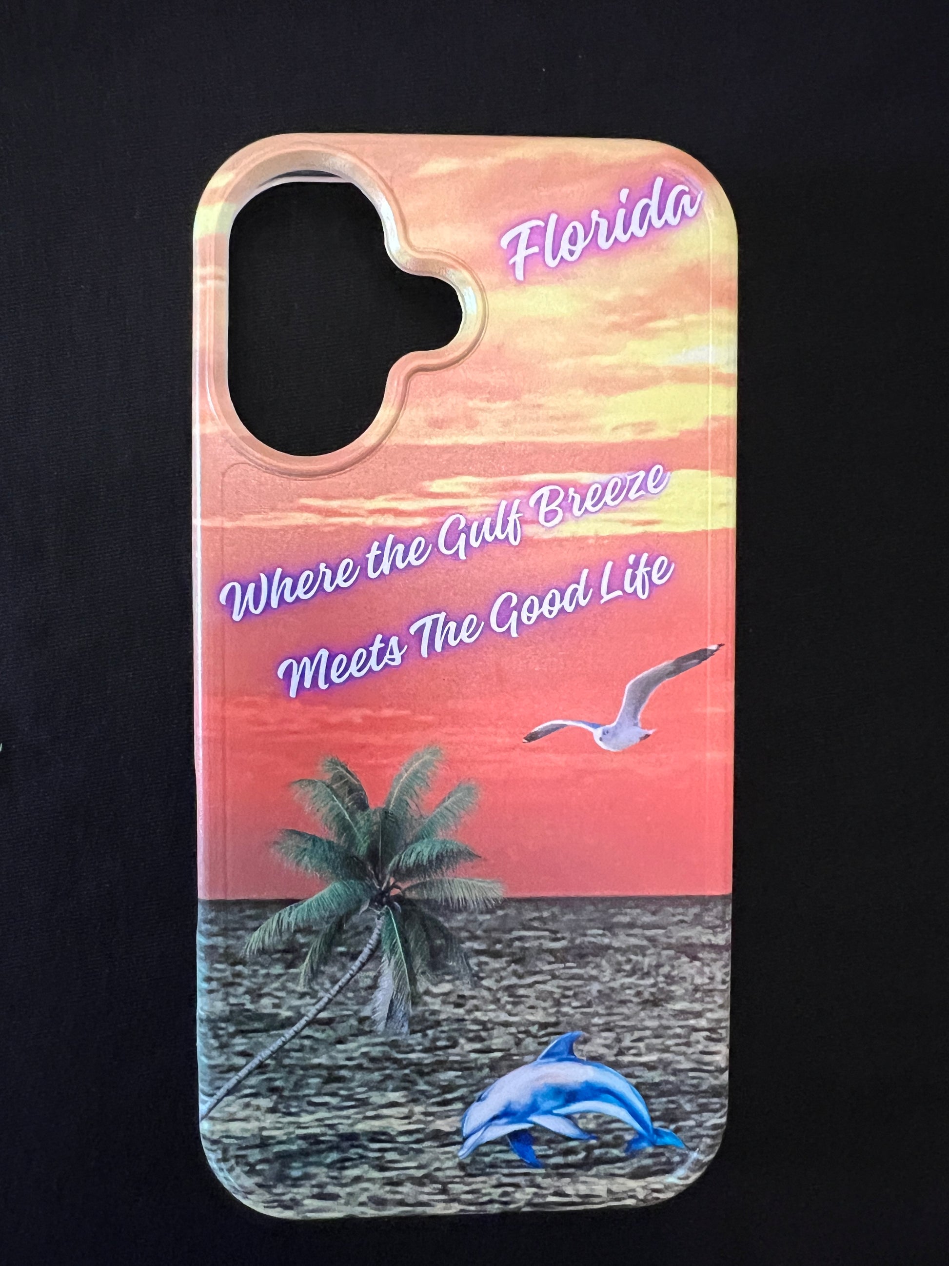 Phone case with Florida design featuring palm tree, dolphin jumping out of the water, seagull jumping out of the gulf water, beautiful Florida sunset, and text with the phrase "where the gulf breeze meets the good like" Florida