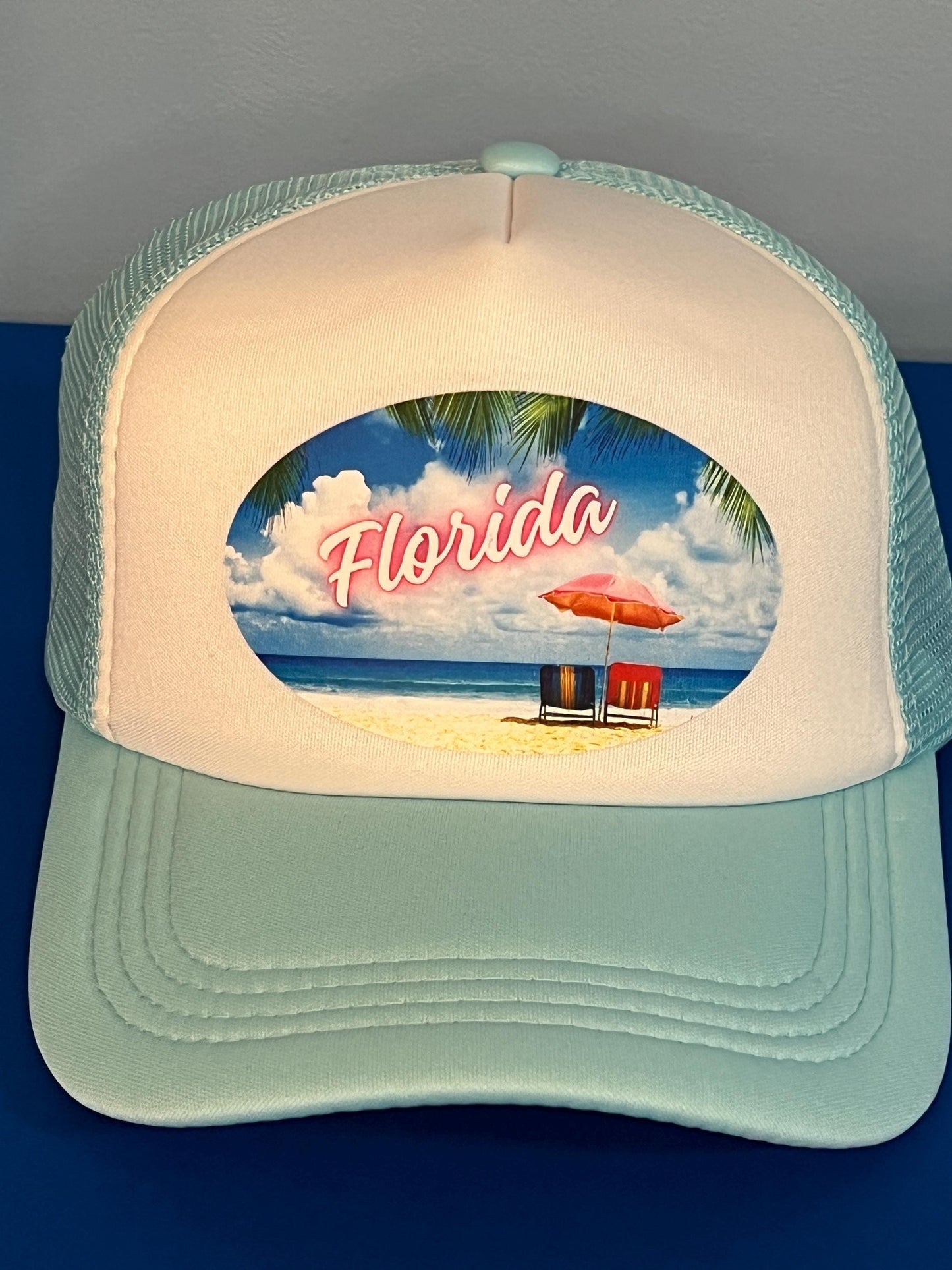 Blue and white Cap with 'Florida' beach scene design on a blue background