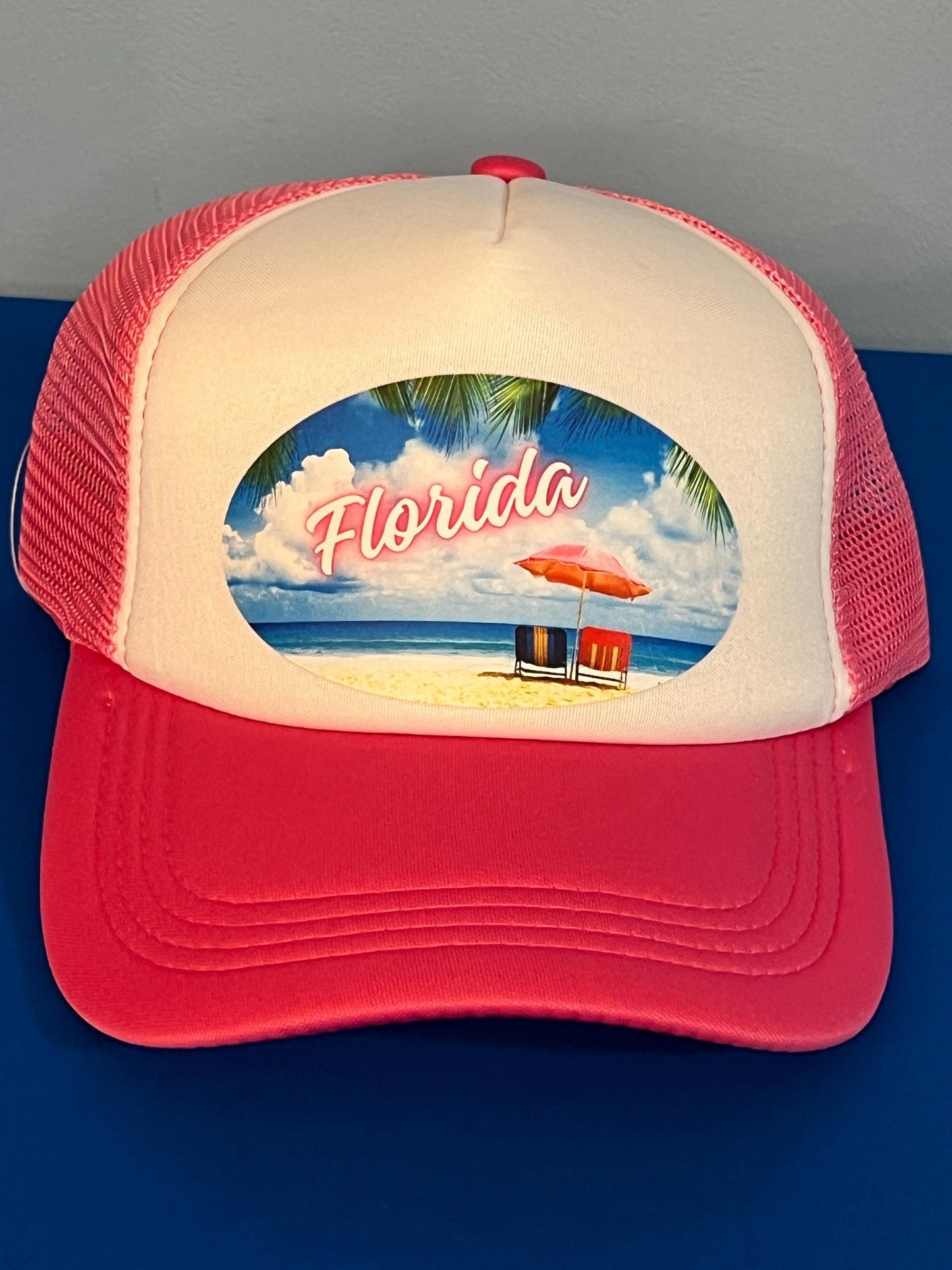 Pink and white trucker hat with 'Florida' beach scene design on a blue background
