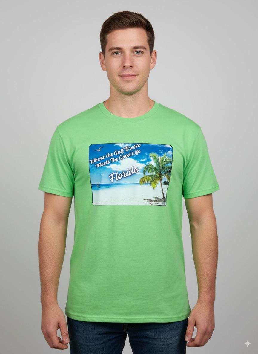 Person wearing a lime green 'Florida' t-shirt on a beach with a sailboat and palm trees in the background. T-shirt has a  picture on the front of white sand beach, aqua gulf waters, palm tree and the text "where the gulf breeze meets the good life" Florida. 